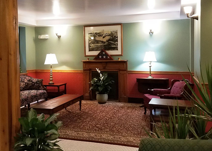 Photo of a lounge area with couch, chairs, a fireplace, and other decor.